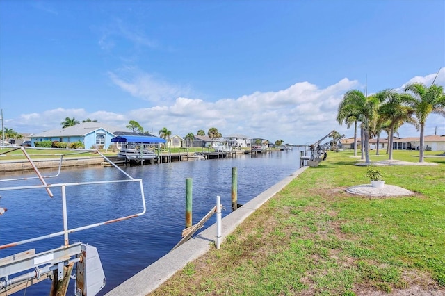 dock area with a residential view, a lawn, and a water view