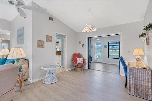 interior space featuring ceiling fan with notable chandelier, light hardwood / wood-style flooring, and lofted ceiling