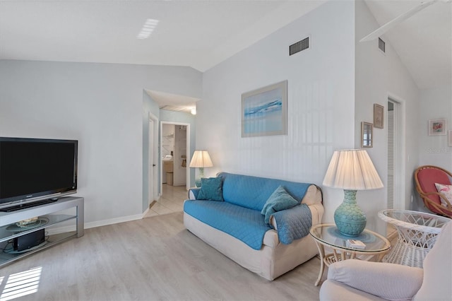 living area with visible vents, wood finished floors, baseboards, and vaulted ceiling