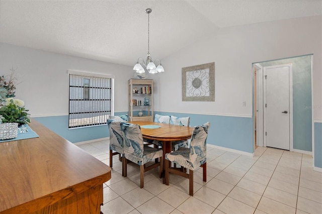 tiled dining area featuring a notable chandelier and vaulted ceiling