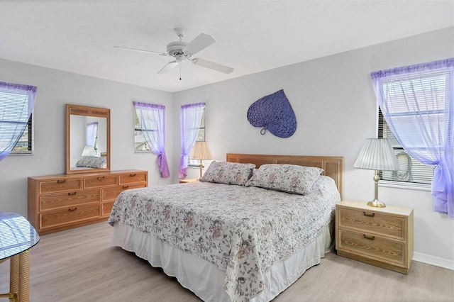 bedroom with multiple windows, light hardwood / wood-style flooring, and ceiling fan