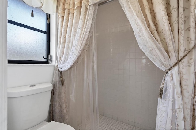 bathroom with tiled shower and toilet