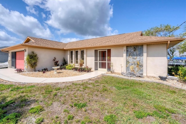 view of front of property featuring a front lawn and a garage