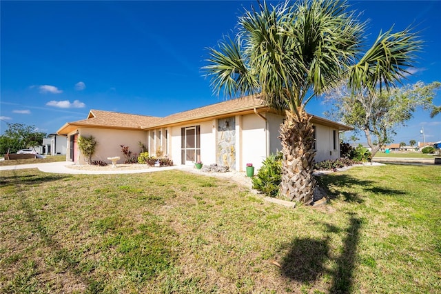 single story home with stucco siding and a front lawn