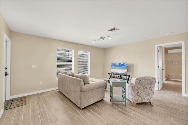 living room with rail lighting and a wall mounted air conditioner