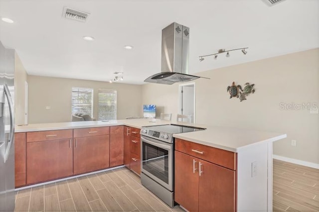 kitchen with island exhaust hood, kitchen peninsula, and stainless steel electric range oven