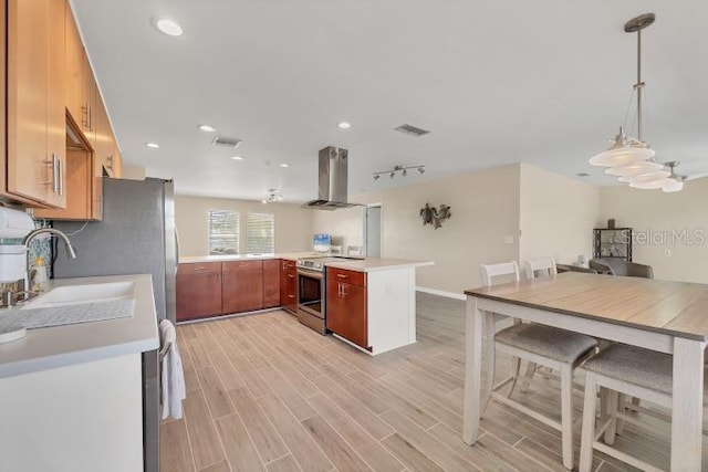 kitchen featuring kitchen peninsula, track lighting, exhaust hood, electric range, and hanging light fixtures