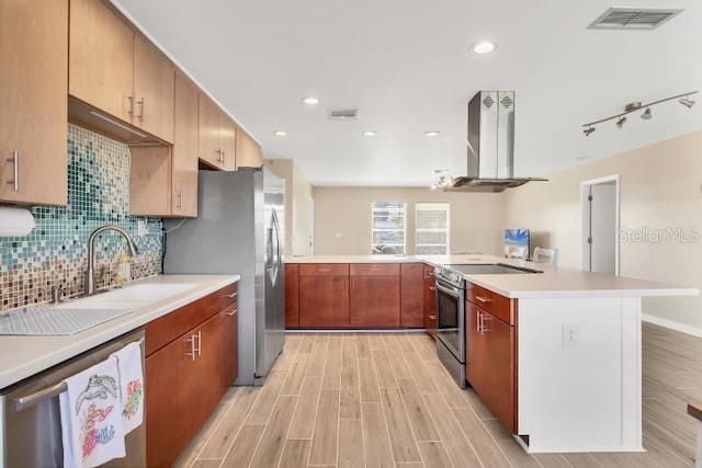 kitchen with sink, light hardwood / wood-style flooring, appliances with stainless steel finishes, tasteful backsplash, and island exhaust hood