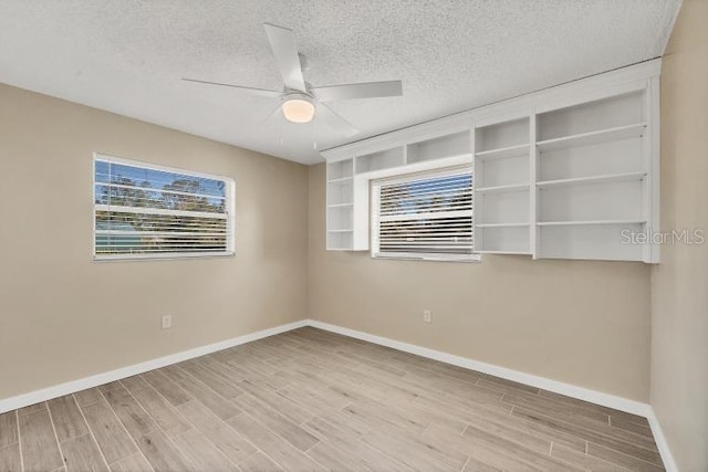 spare room with ceiling fan, a textured ceiling, and light hardwood / wood-style flooring