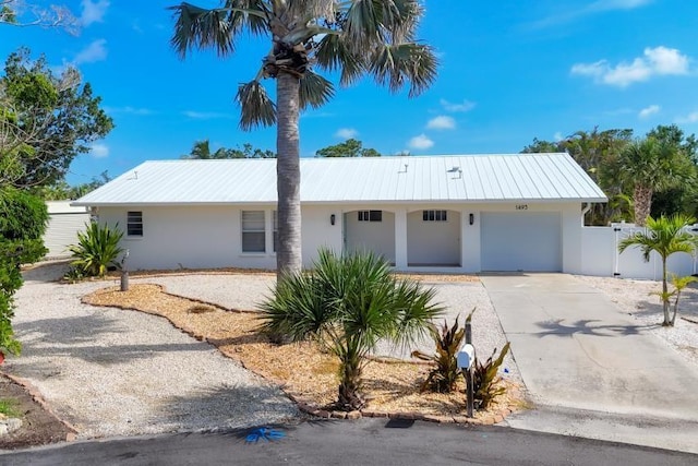 1493 Janet Pl, Englewood, FL 34223 - single story home with stucco siding, driveway, a garage, and a metal roof