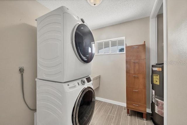 1493 Janet Pl, Englewood, FL 34223 - laundry area featuring stacked washer / dryer, wood tiled floors, and a textured ceiling