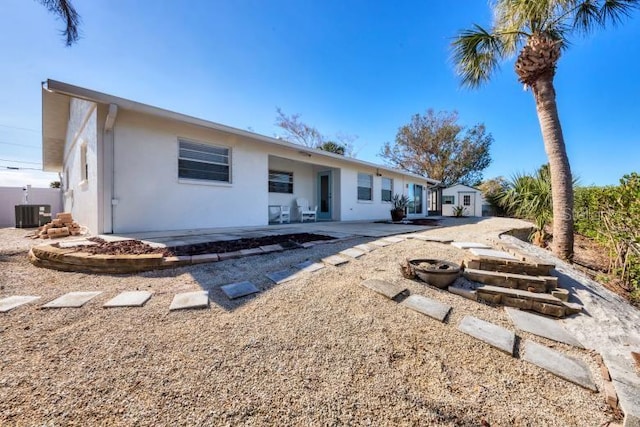 1493 Janet Pl, Englewood, FL 34223 - back of property featuring stucco siding, a patio area, and a storage unit