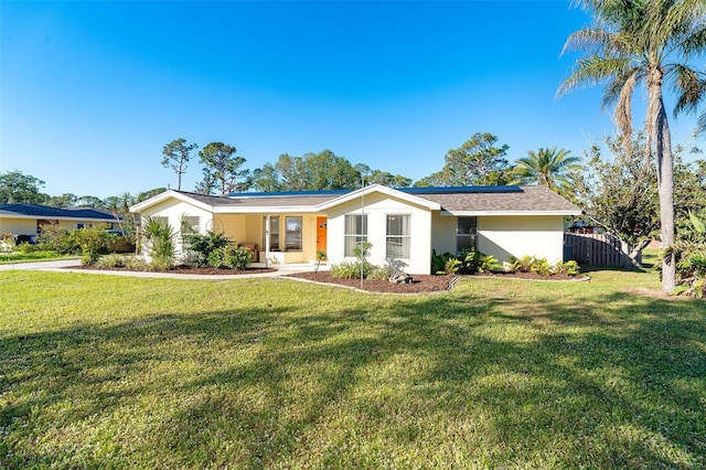 single story home with solar panels and a front yard