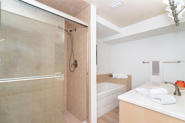 bathroom with hardwood / wood-style flooring, vanity, and separate shower and tub