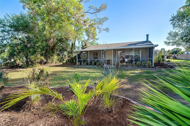 back of house featuring a sunroom and a lawn