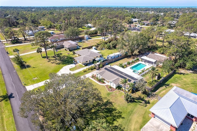 drone / aerial view featuring a wooded view and a residential view