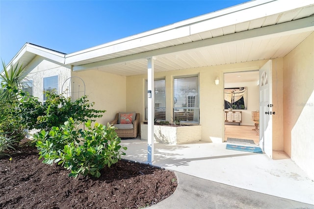 entrance to property featuring a patio and stucco siding