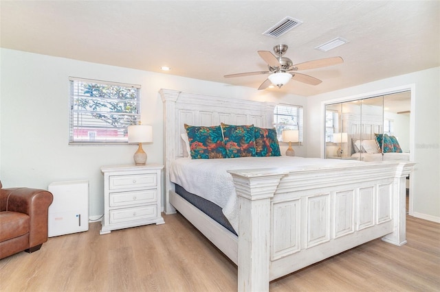 bedroom with light wood-style floors, visible vents, ceiling fan, and baseboards