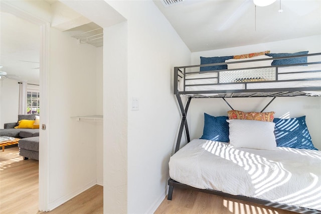 bedroom featuring ceiling fan, light wood-type flooring, visible vents, and baseboards