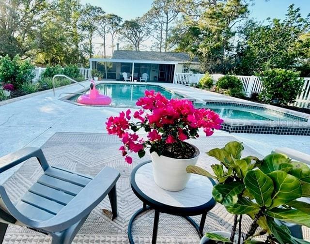 view of swimming pool featuring a fenced in pool, fence private yard, a patio, and an in ground hot tub