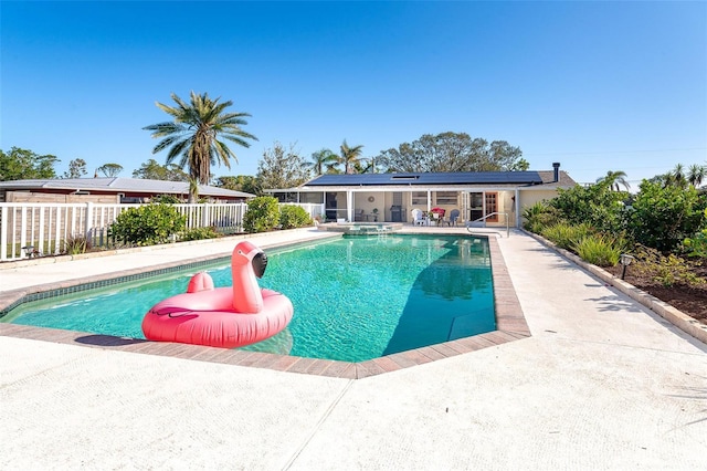 view of swimming pool featuring a patio, fence, and a pool with connected hot tub