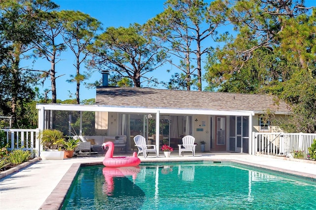 view of pool featuring a patio area, fence, a sunroom, and a fenced in pool