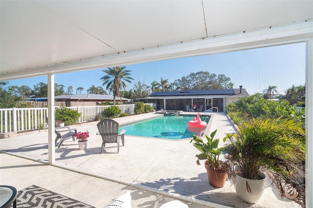 view of pool featuring a patio, fence, and a pool with connected hot tub