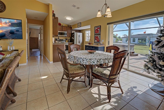 dining room with a chandelier and light tile patterned floors