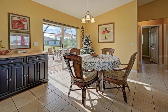 dining room featuring a notable chandelier, lofted ceiling, and light tile patterned flooring