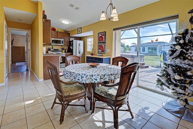 dining space featuring light tile patterned floors and a chandelier