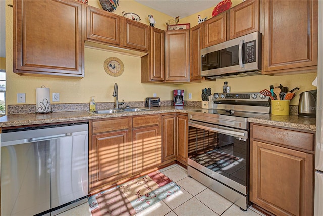 kitchen with sink, light tile patterned floors, and appliances with stainless steel finishes