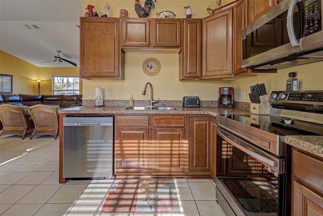 kitchen featuring stainless steel appliances, ceiling fan, sink, light tile patterned floors, and lofted ceiling