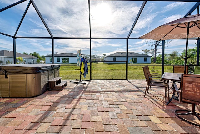 view of patio / terrace featuring glass enclosure and a hot tub