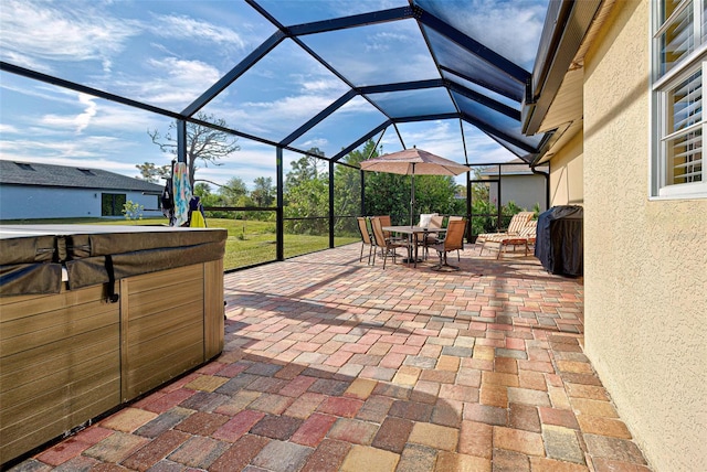 view of patio with a lanai, area for grilling, and a hot tub