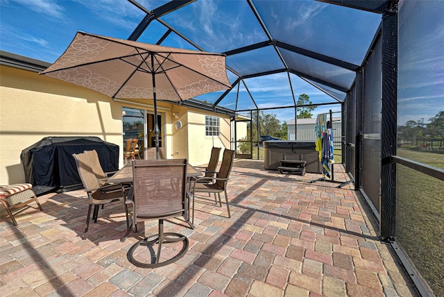 view of patio / terrace with area for grilling, glass enclosure, and a hot tub