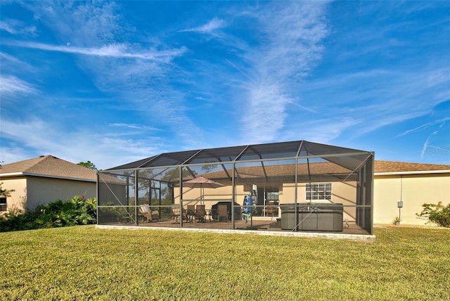 rear view of property with a lanai, a yard, a patio, and a hot tub