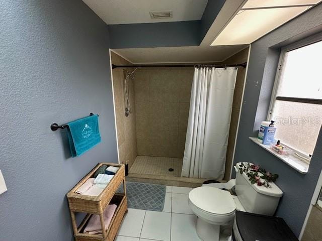 bathroom featuring tile patterned floors, a shower with shower curtain, and toilet