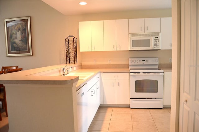 kitchen featuring kitchen peninsula, white appliances, sink, light tile patterned floors, and white cabinets