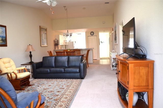 carpeted living room with lofted ceiling and ceiling fan with notable chandelier