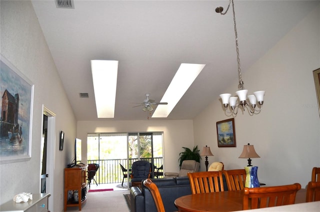 dining room featuring ceiling fan with notable chandelier and lofted ceiling with skylight