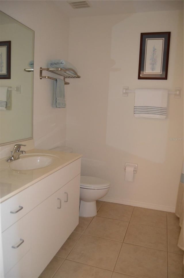 bathroom with tile patterned flooring, vanity, and toilet