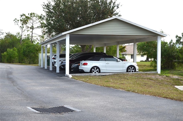 view of parking / parking lot featuring a carport and a lawn