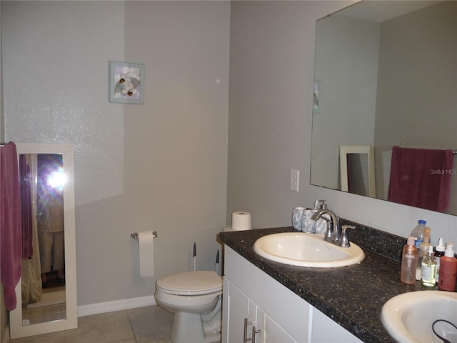 bathroom with tile patterned flooring, vanity, and toilet