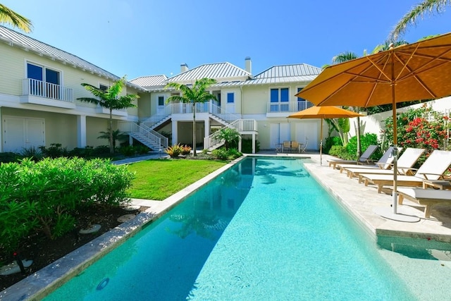 view of swimming pool with a yard and a patio