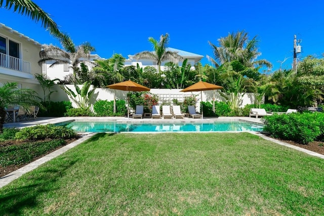 view of pool featuring a lawn