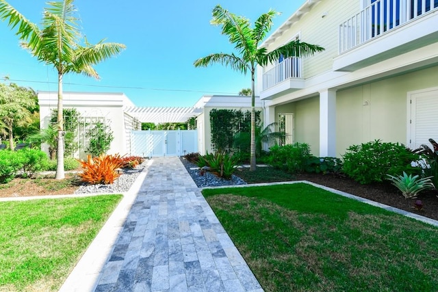 view of yard featuring a pergola and a balcony