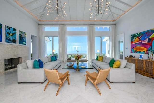 living room featuring a high end fireplace, a chandelier, and a towering ceiling