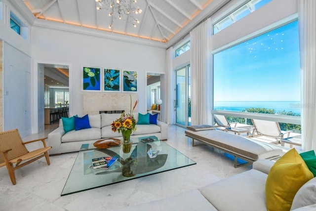 sunroom featuring vaulted ceiling, a water view, and a healthy amount of sunlight