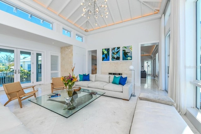 interior space featuring plenty of natural light, a chandelier, lofted ceiling, and french doors