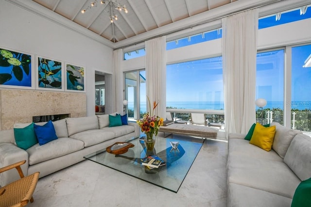 sunroom with a fireplace, lofted ceiling, a water view, and an inviting chandelier